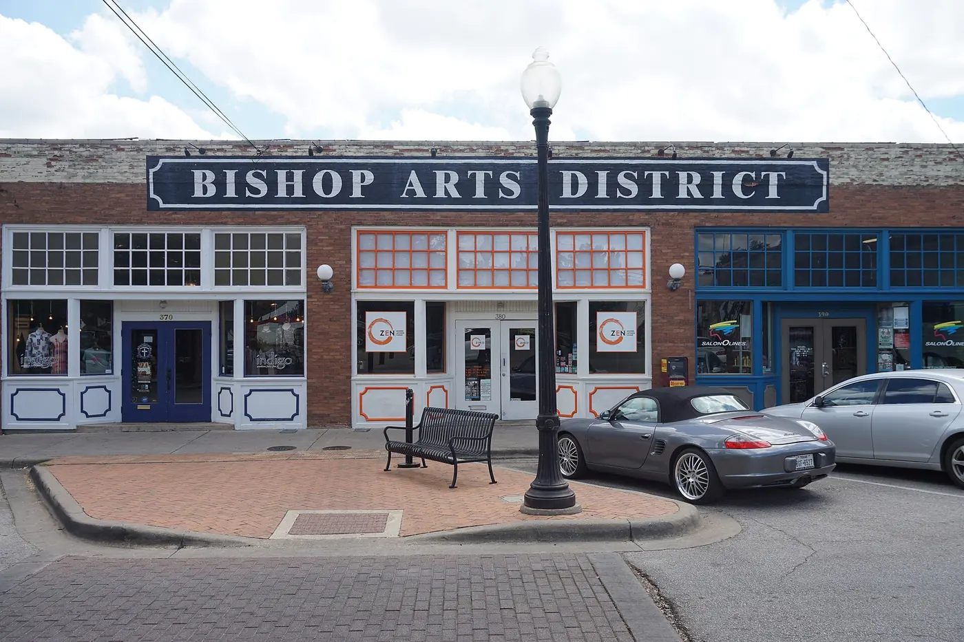 A row of small storefronts under a Bishop Arts District sign in Dallas