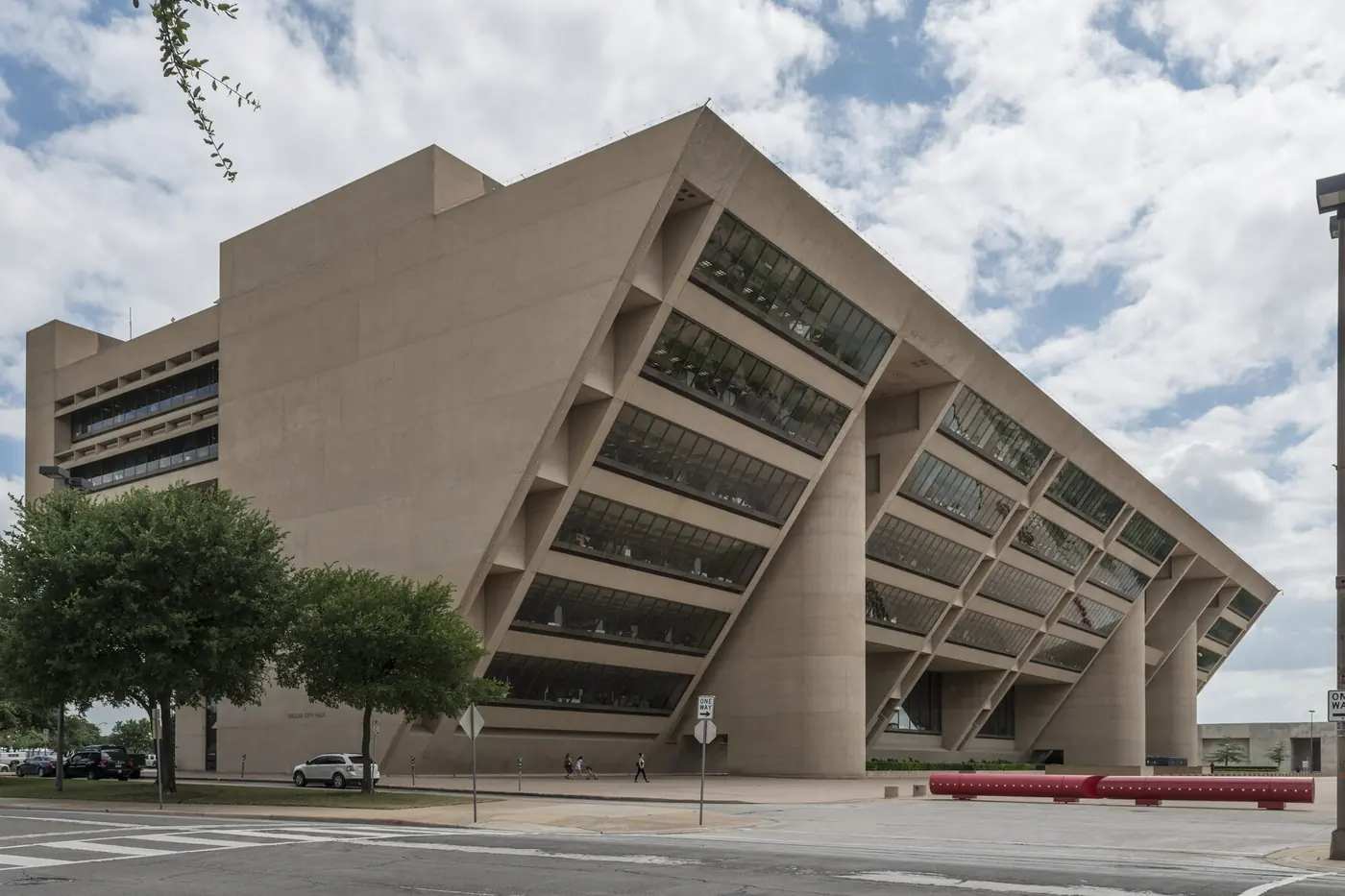 Dallas City Hall, the angled concrete building designed by I. M. Pei, under a partly cloudy sky